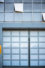 Glass garage doors and part of the outer wall of modern high-rise building