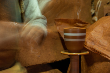 Craftsman artist making craft, pottery, sculptor from fresh wet clay on pottery wheel, long exposure