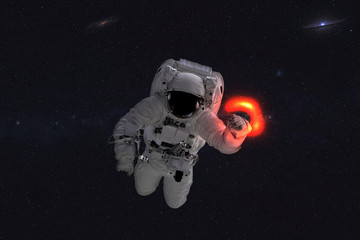 Space astronaut near black hole red glow. Space adventure in outer space. Science fiction. Elements of this image were furnished by NASA