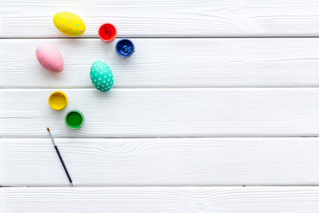 eggs with colorful paint for easter tradition on white wooden background top view mockup