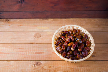Dried dates on wooden background. Holy month of Ramadan, concept. Righteous Muslim lifestyle. Starvation. Dates in a wooden basket in the style of minimalism. Copy space