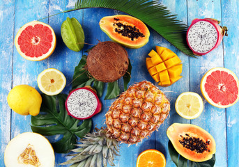 Fresh tropical Fruits on the beach with a palm leave. Assorted tropical fruits, orange,Ananas or pineapple and mango