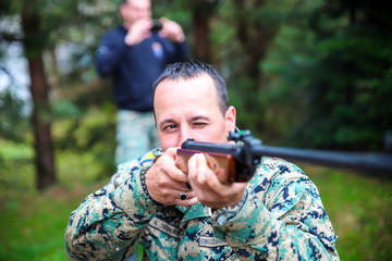 A Marine with a uniform of American marines stands hidden and observes a dangerous area