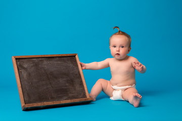 baby sitting and holding a chalkboard,Baby happy on the blue background, new family and love concept , copy space