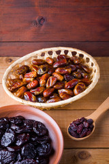 Dried dates and prunes on wooden background. Holy month of Ramadan, concept. Righteous Muslim lifestyle. Starvation. Dried fruits: dates, prunes and raisins on wooden boards