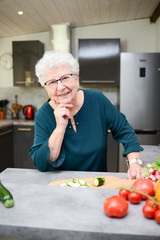 Fototapeta na wymiar happy senior active woman cooking at home in a modern kitchen