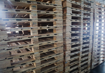 The forklift and wooden pallets heap in the cargo warehouse for transportation and logistics 