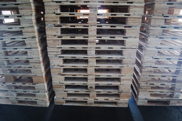 The forklift and wooden pallets heap in the cargo warehouse for transportation and logistics 