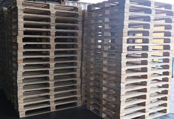 The forklift and wooden pallets heap in the cargo warehouse for transportation and logistics 