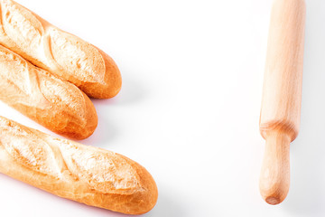 Freshly baked French baguettes on white wooden table.
