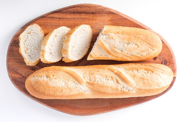 Freshly baked French baguettes on white wooden table.