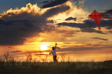 Fototapeta na wymiar Boy with a kite at sunset