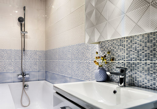 Small bathroom in beige and blue tones, the walls are tiled.