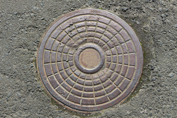 cast iron manhole on asphalt background