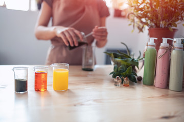 woman makes handmade cosmetics on wooden table;
