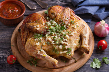 Roasted chicken with garlic on wooden tray