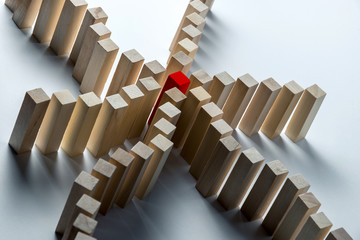 Many curved lines of wooden cubes are combined in the center into one red, as a symbol of queues, a variety of tasks and a leader, on an uneven white background. Horizontal frame