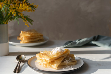 Morning, breakfast - traditional russian blini pancakes, french crepes whipped cream, mimosa flower