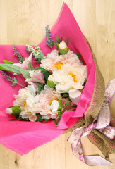 Flowers wrapped in pink tissue and hessian modern trend wrapping flat lay for Mother's Day, birthday or Valentine's Day celebrations.
