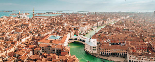 Aerial panoramic view of famous Canal Grande and famous Rialto Bridge at sunset in Venice, Italy.