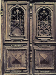 Wooden door of a building on the street with an iron decorative ornament. Old Tbilisi architecture
