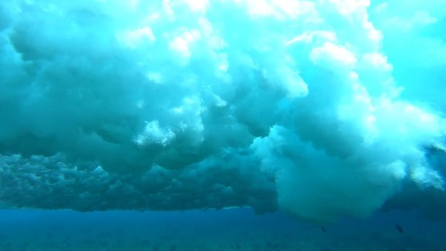 Underwater view of the crystal clear wave breaking over the reef