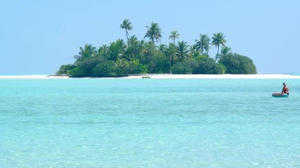 Coconut palms over a tiny, exotic island paradise with white sand beaches
