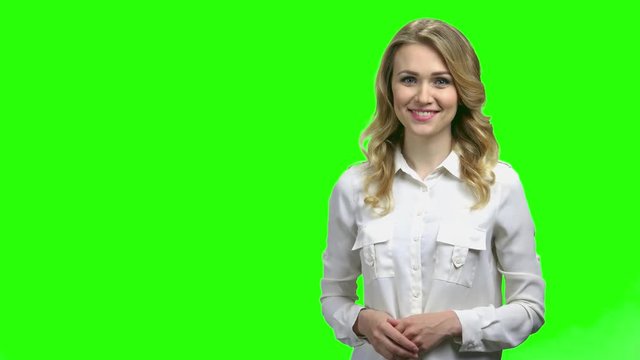 Young charming woman presenting something on green screen. Pretty caucasian woman presenting the weather forecast. Chroma Key background.