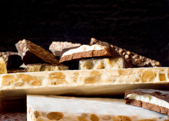 Turron. Traditional Spanish Christmas candy. Torrone and nougat with nuts. Selective focus. Blurred background. Texture, layers.