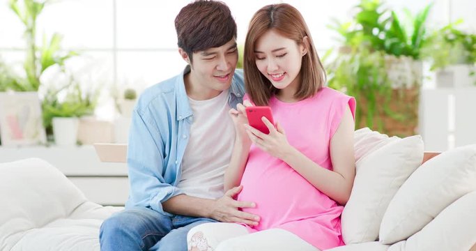 Pregnant couple use smart phone