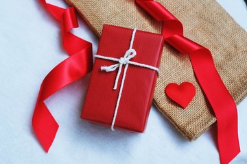 Group of elegant red gift box stack decorated with mini heart figure on wood background, vibrant valentine lovely present concept