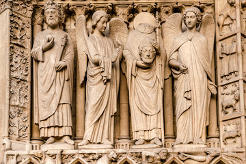 Fototapeta na wymiar The four large statues of the left-hand side of the portal of the Virgin represent an unidentified king and Saint Denis decapitated