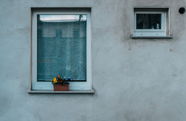Fototapeta na wymiar Dirty gray facade with big and little window