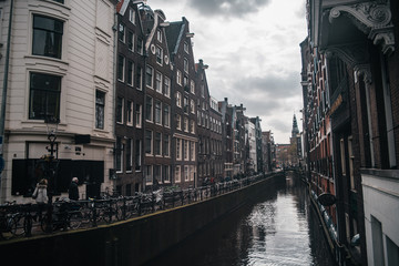 Fototapeta na wymiar Cozy european architecture with river canal. Amsterdam beautiful houses