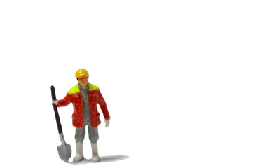 Selective focus miniature workers with yellow safety helmet and orange jacket uniform.  Industrail business conception.