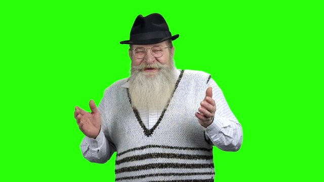 Elderly bearded man is laughing on green screen. Old joyful man with beard is laughing. Alpha Channel background.