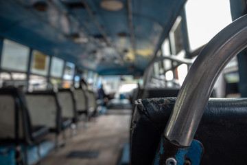 Close-up of iron bar of the seat on blurred empty bus background with copy space