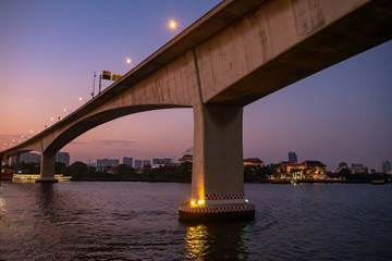 Fototapeta premium New concrete bridge over the river with romantic cityscape scene on twilight sky background