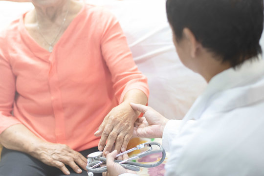 Doctor hand with stethoscope check up elderly woman people. Old aging female seeing medical physician in clinical healthcare hospital.