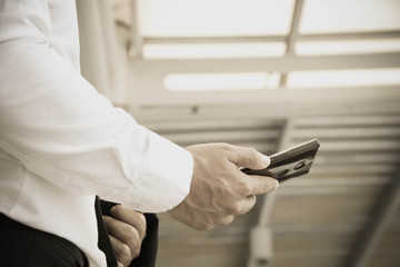 Naklejka premium Businessman standing using a smartphone to schedule an appointment in the work.