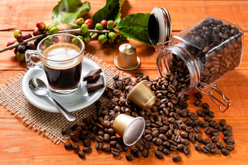 Glass of clear glass of hot coffee on wooden table. Orange wood pinus.