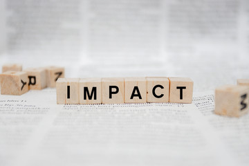 Impact Word Written In Wooden Cube - Newspaper