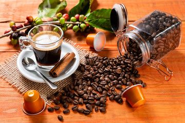 Glass of clear glass of hot coffee on wooden table. Orange wood pinus.