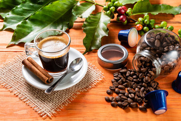 Glass of clear glass of hot coffee on wooden table. Orange wood pinus.