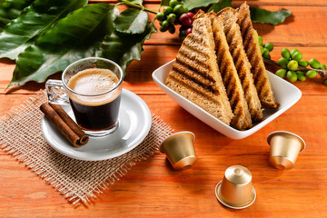 Glass of clear glass of hot coffee on wooden table. Orange wood pinus.