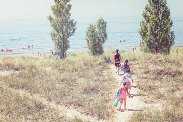 Children walking up a dune path to the beach