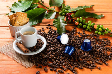 White cup of hot coffee on wooden table. Orange wood pinus.
