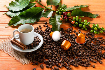 White cup of hot coffee on wooden table. Orange wood pinus.