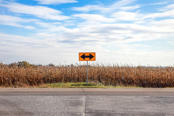 A double arrow sign on a country road