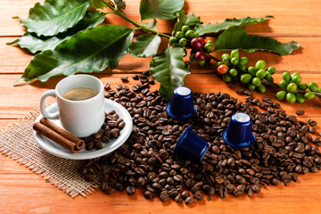 White cup of hot coffee on wooden table. Orange wood pinus.